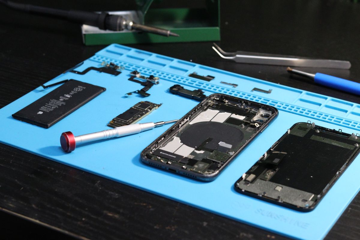 Smartphone desmontado em bancada de reparo