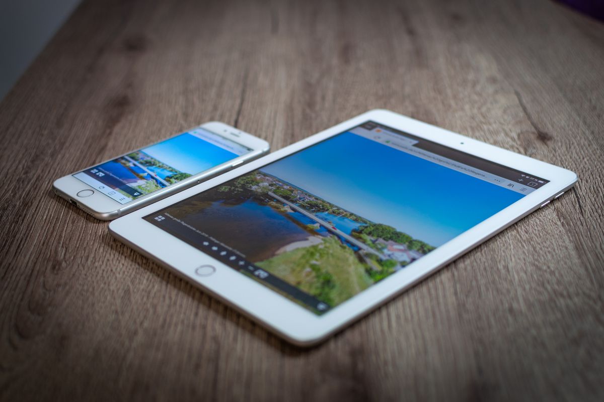 Tablet e celular sobre uma mesa de madeira